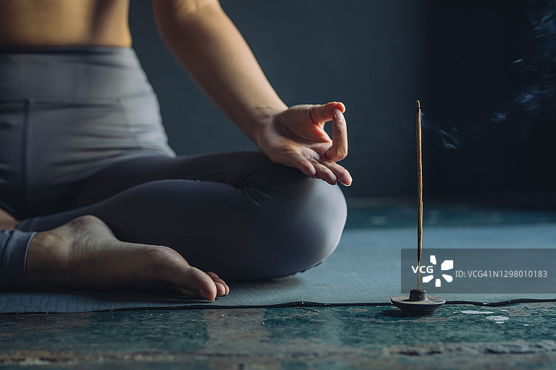 冥想的匿名女人，旁边点着香图片素材