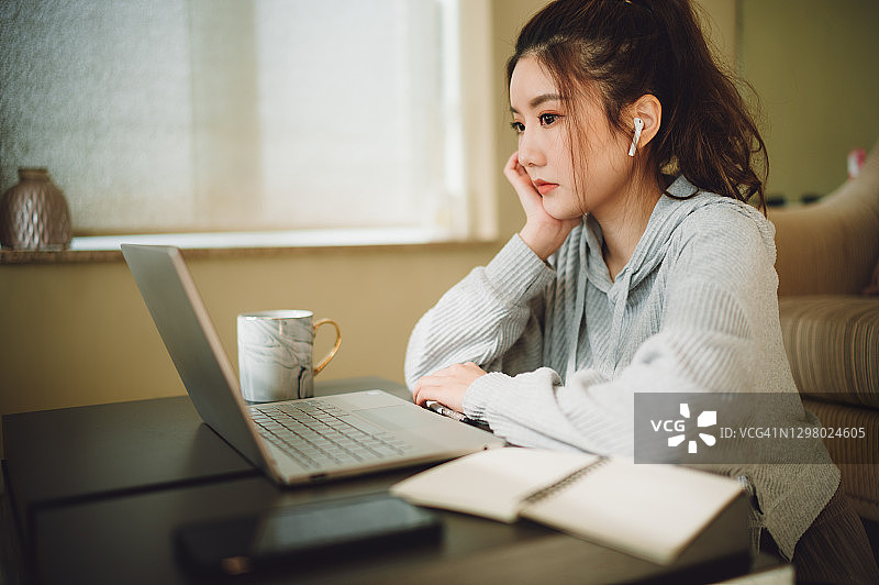 年轻的亚洲女商人在家工作时感到无聊的镜头图片素材