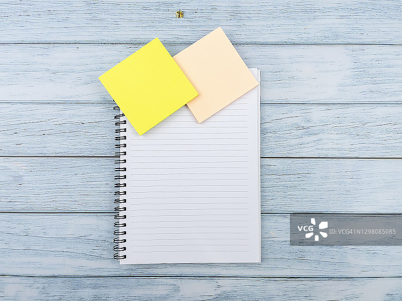 蓝色木纹桌面上的空白便签和记事本图片素材