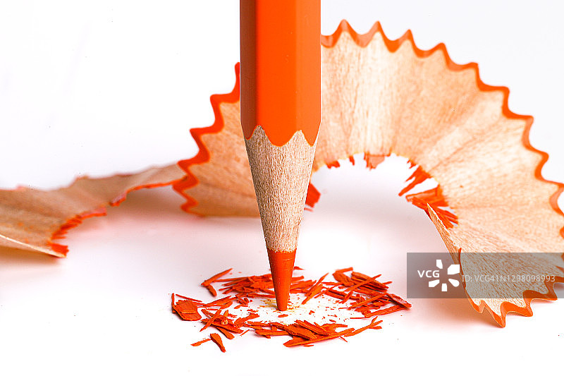 橙色铅笔和刨花在白纸背景上图片素材