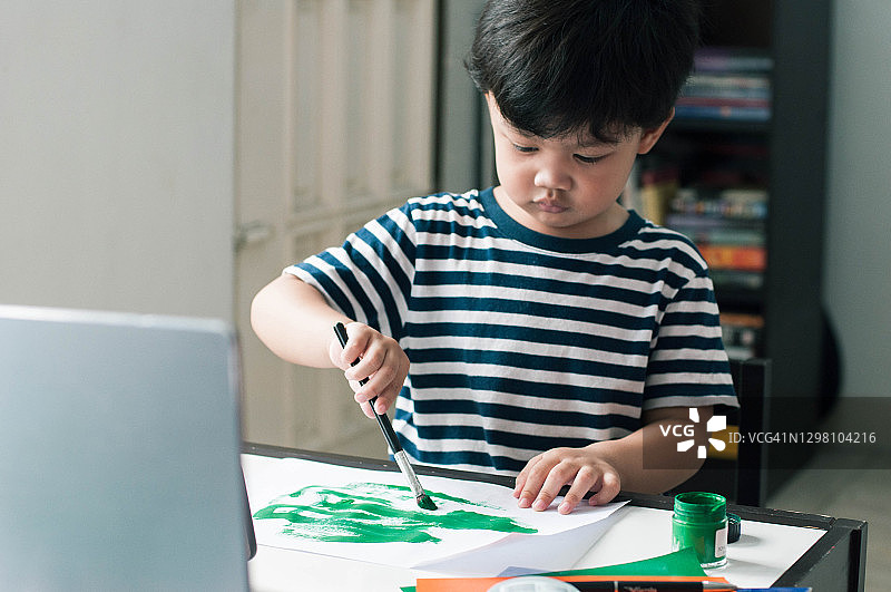 一名东南亚男童在使用笔记本电脑进行教育视频通话图片素材
