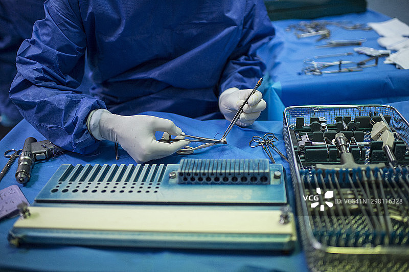 重症监护室里准备手术镊子的男orthopedic外科医生图片素材