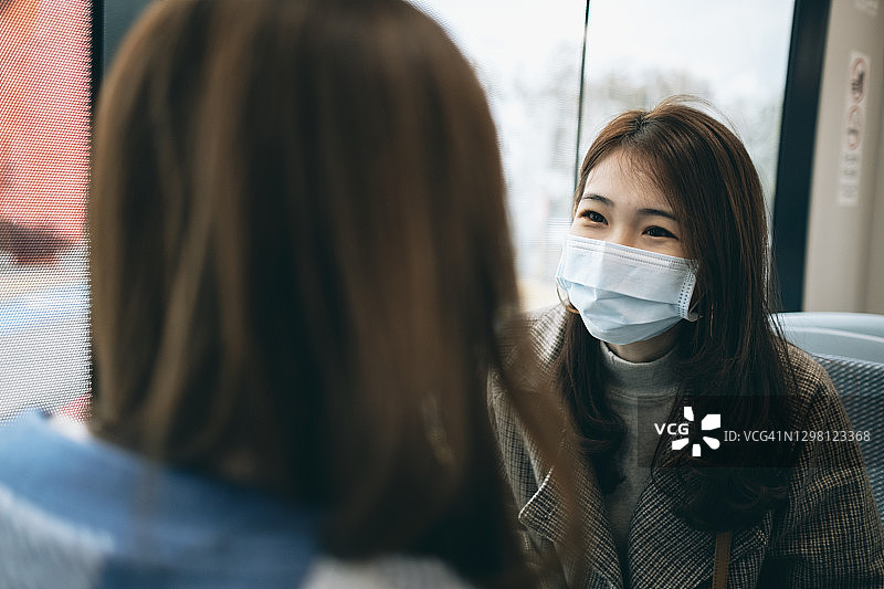 两名亚洲女性在火车上交谈图片素材