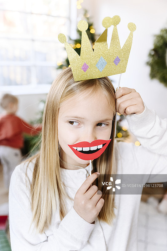 在家手持皇冠和嘴唇道具的女孩特写图片素材