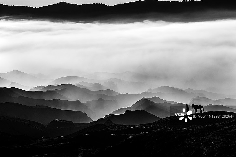 布罗莫火山山坡上的当地人或骑马者剪影图片素材