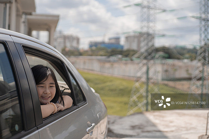 中国女孩在公路旅行中从后座看车窗外图片素材