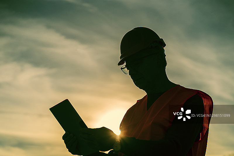 身穿工作服使用数字平板电脑的建筑工程师图片素材
