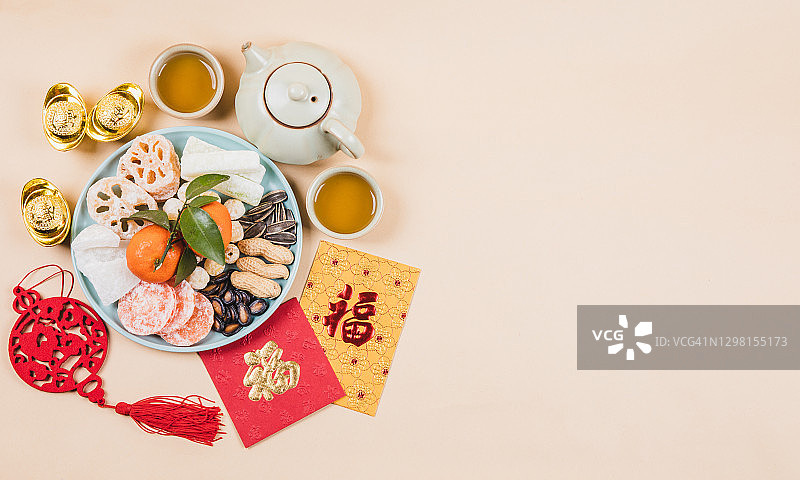 中国新年传统小吃和茶，以及红包和新年装饰品的俯视图图片素材