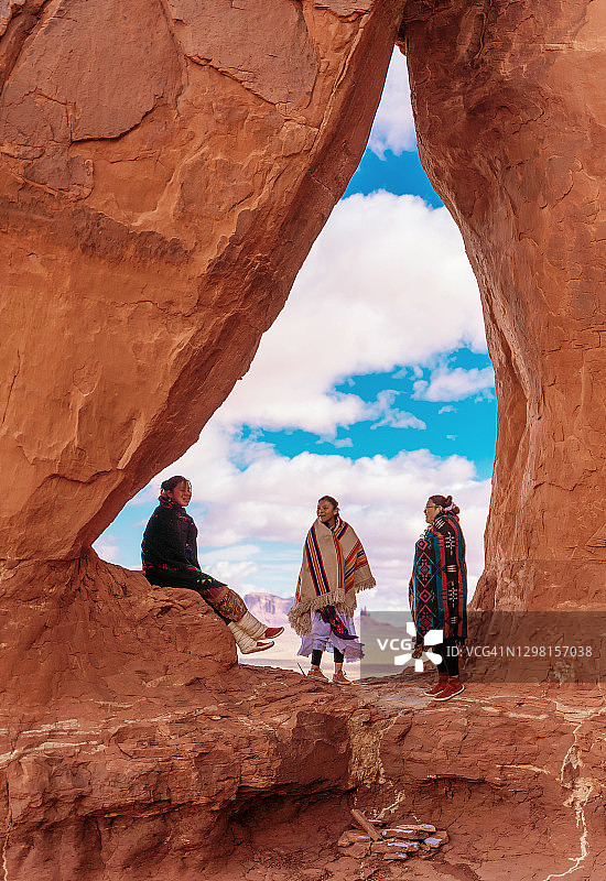 亚利桑那州纪念碑谷泪珠拱门下的纳瓦霍族姐妹图片素材
