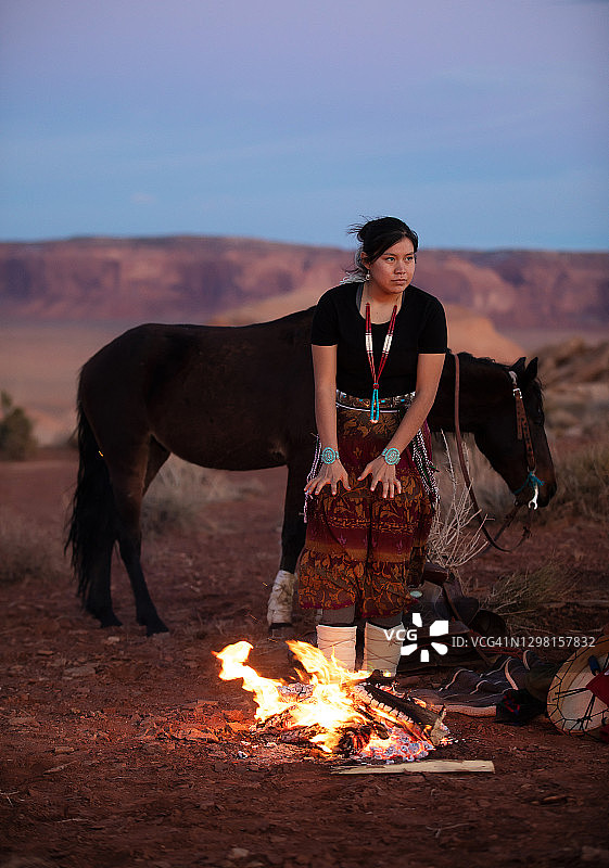 纳瓦霍族妇女在纪念碑谷的篝火旁取暖图片素材