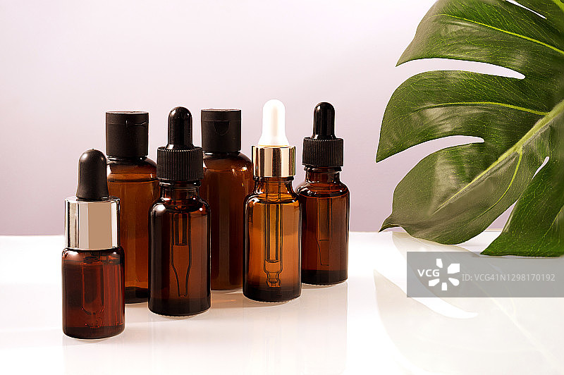 米色背景上的各种按摩油、面部精华液和身体霜图片素材