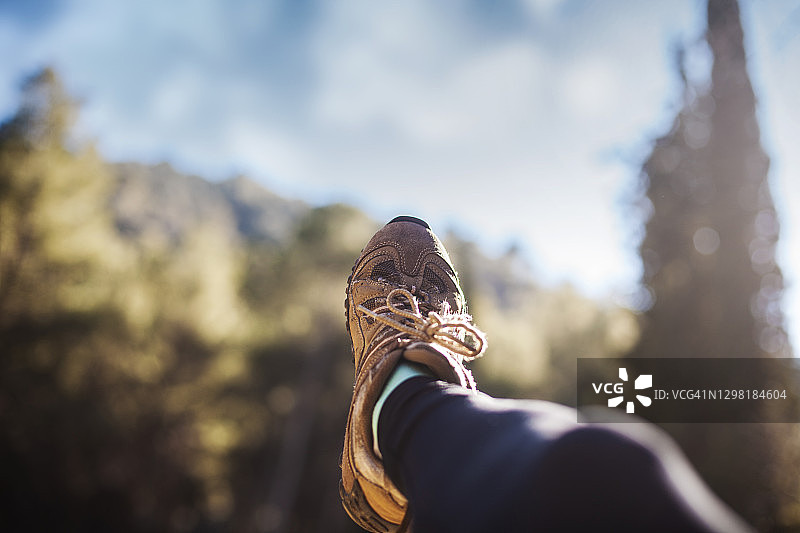 户外田野中，某人穿着步行靴躺卧，乡村景色为背景图片素材