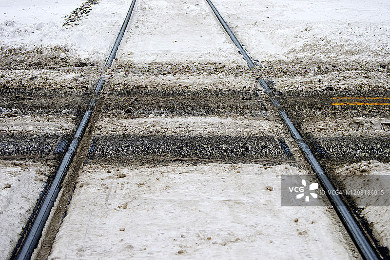 穿越道路的雪地火车轨道图片素材