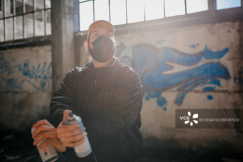 手持喷漆罐的年轻涂鸦艺术家图片素材