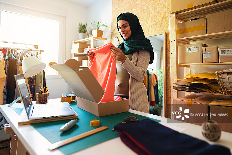 年轻的穆斯林小企业主打包准备发货。图片素材