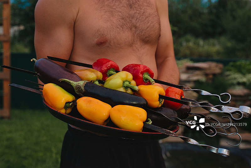 男子手持蔬菜串图片素材