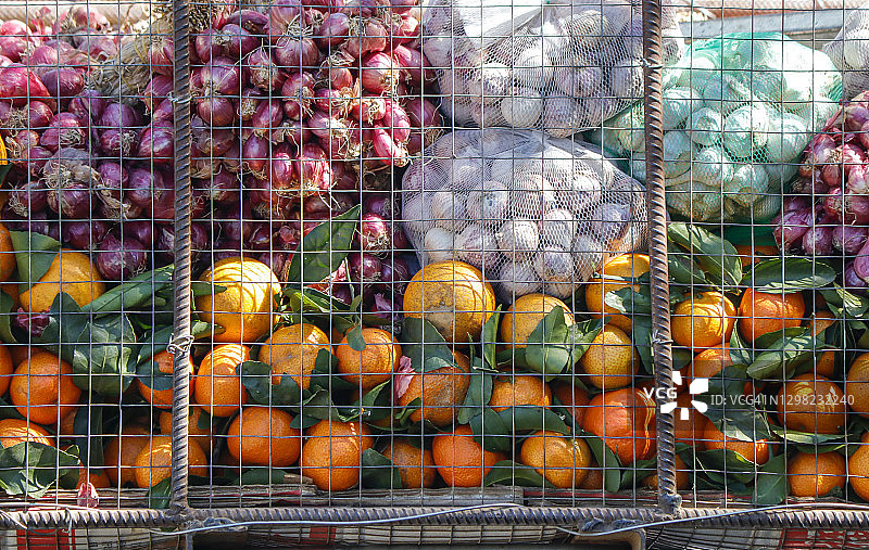 越南市场售卖金属篮中的金桔、洋葱和大蒜图片素材