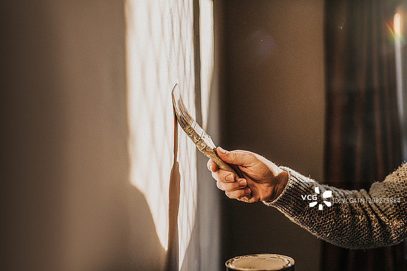 男人用画笔粉刷墙壁的特写图片素材