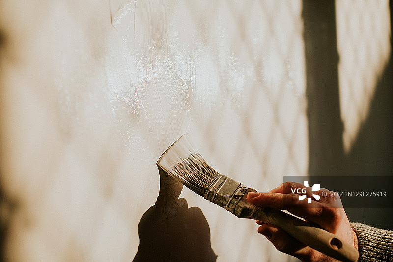 男人用画笔粉刷墙壁的特写图片素材