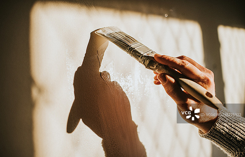 男人用画笔粉刷墙壁的特写图片素材