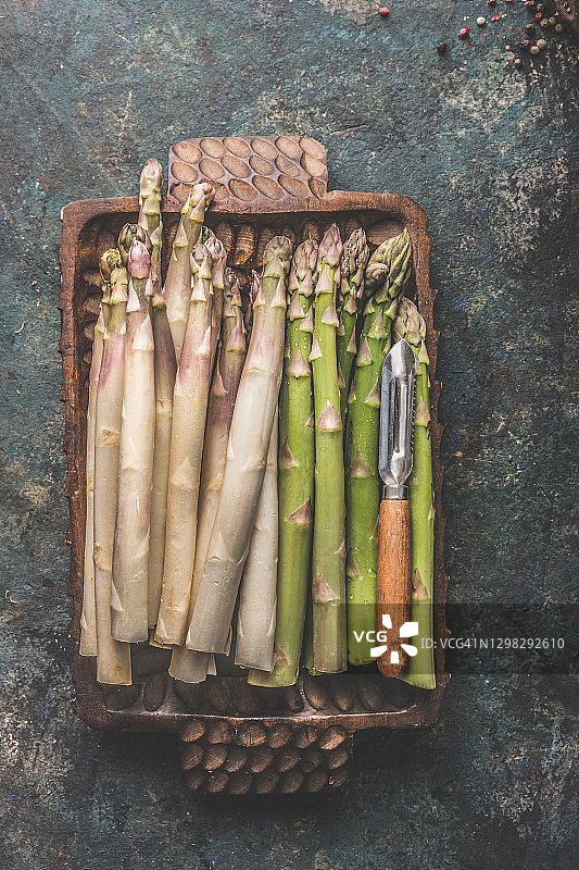 木碗里的绿白芦笋和复古削皮器图片素材