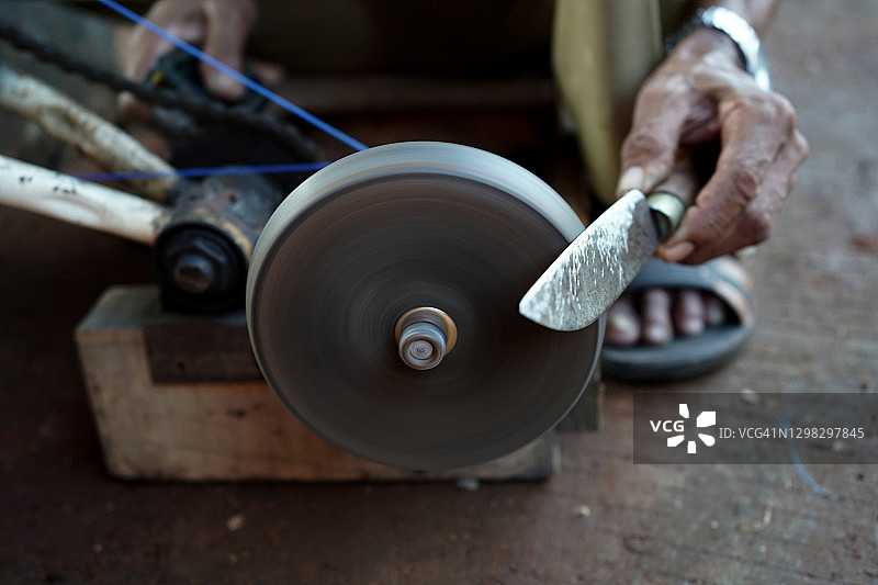 男子手工磨刀图片素材