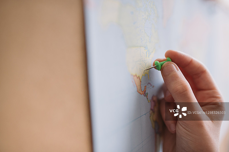 女孩在世界地图上插图钉的特写图片素材