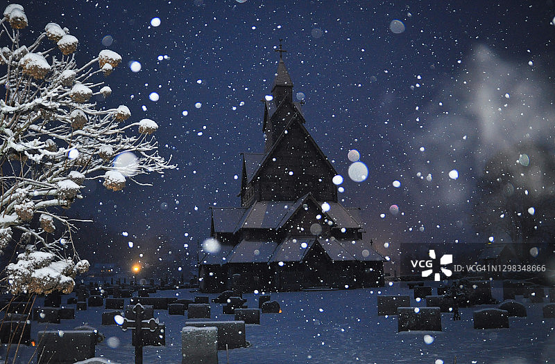 冬季傍晚的木板教堂和树木，有降雪图片素材