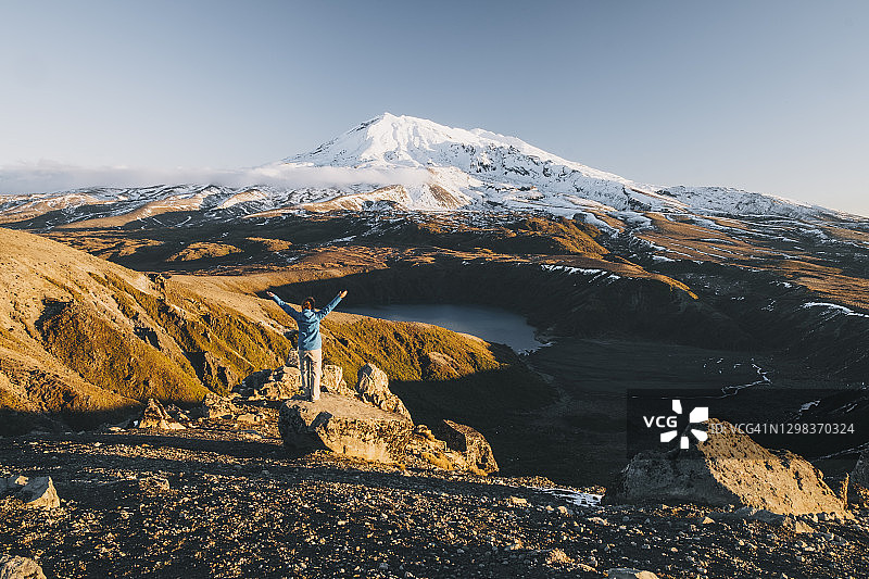 年轻女人在鲁阿佩胡山和塔玛湖前张开双臂庆祝，新西兰图片素材