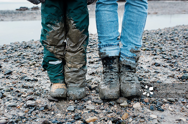 海边散步后父子腿上沾满泥图片素材