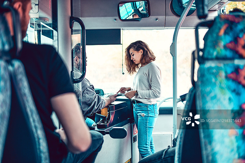 女乘客上车刷卡支付公交车费图片素材