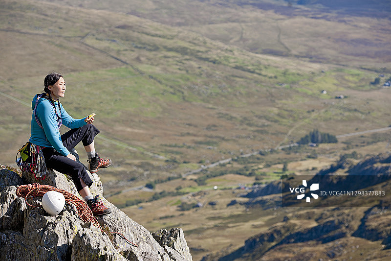在北威尔士Tryfan山上享用三明治的女攀岩者图片素材