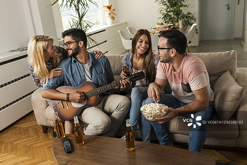 一起玩音乐、喝啤酒的快乐年轻人图片素材