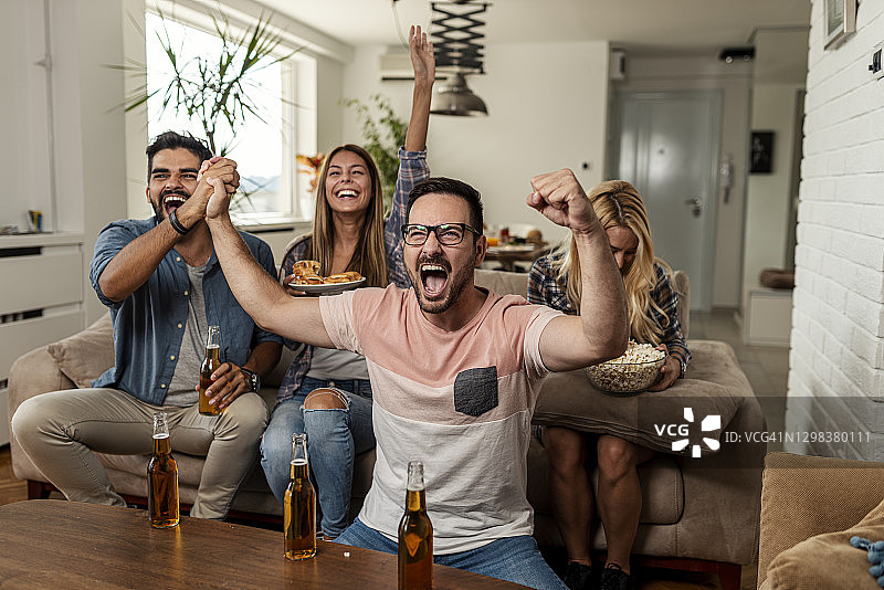 朋友们在电视上看体育比赛图片素材