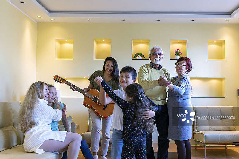 年长的男人和他的妻子在家里跳舞，享受家庭时光图片素材