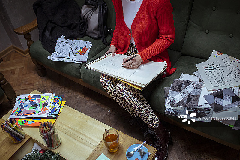 在沙发上绘画的女艺术家图片素材