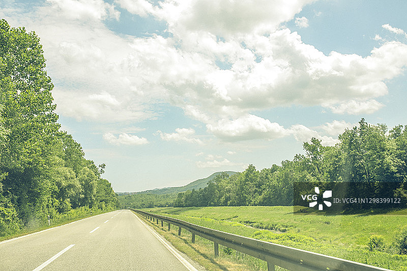 通往茂密森林和山丘的开放道路图片素材