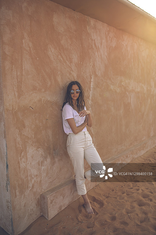 靠在赤陶墙上的年轻女子图片素材