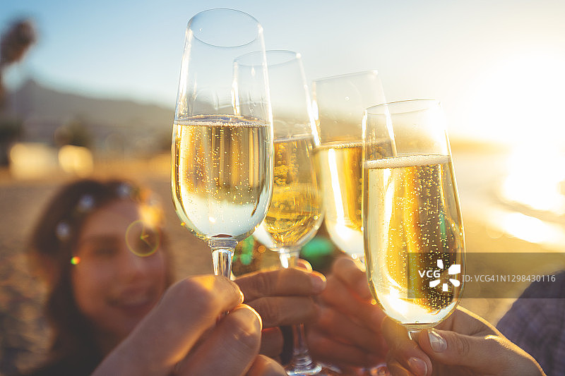 一群朋友在海滩上举杯香槟庆祝图片素材