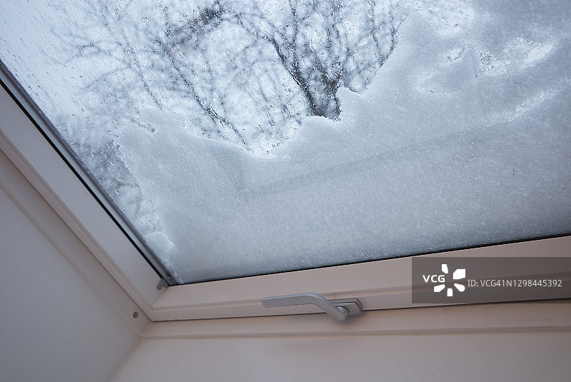 冬季通过天窗看到的玻璃上的雪景局部特写和室内景色图片素材