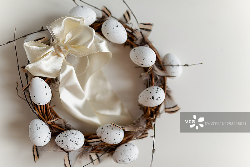 带有柳条、鸡蛋和羽毛的复活节花环图片素材