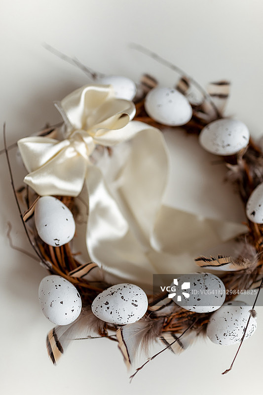 带有柳条、鸡蛋和羽毛的复活节花环图片素材