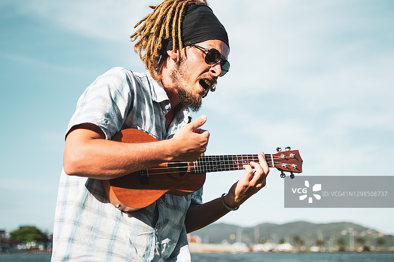 男子在弗洛里亚诺波利斯弹尤克里里并唱歌图片素材