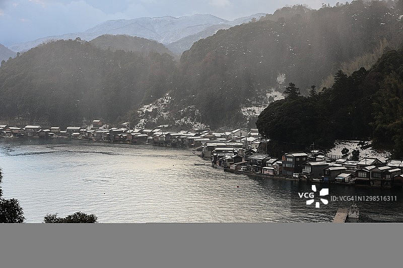 伊根湾的冬季美景：寒冷冬日傍晚，伊根舟屋群上空飘落雨夹雪图片素材