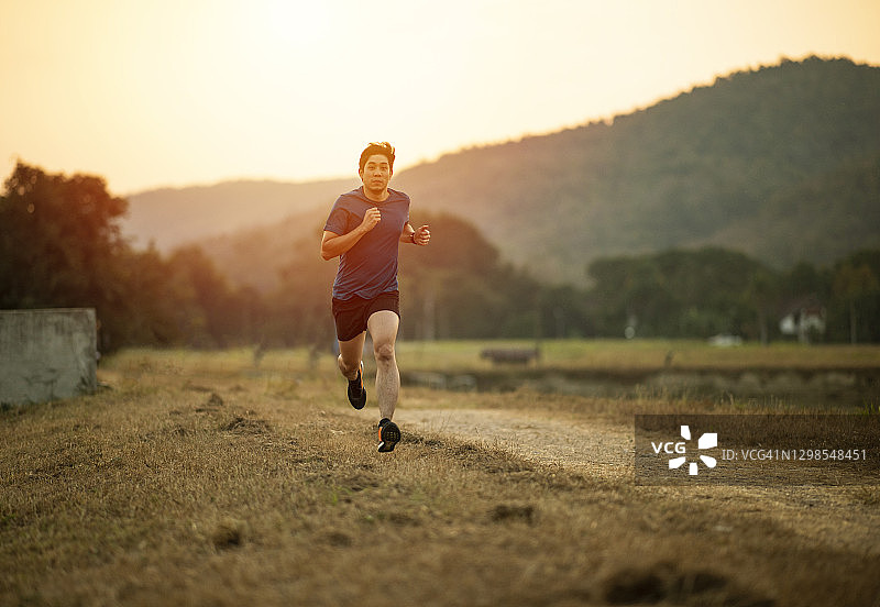 亚洲男人剪影在黄昏日落户外跑步图片素材