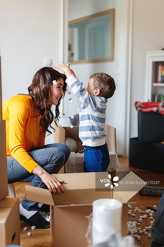 男孩将包装花生倒在妈妈身上图片素材