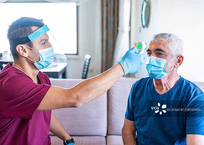 男护士上门拜访，为老年人测量体温，居家护理图片素材