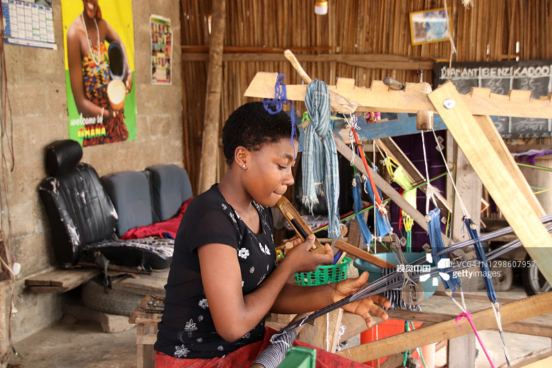 年轻女子在多哥克帕利梅路边编织传统肯特布图片素材