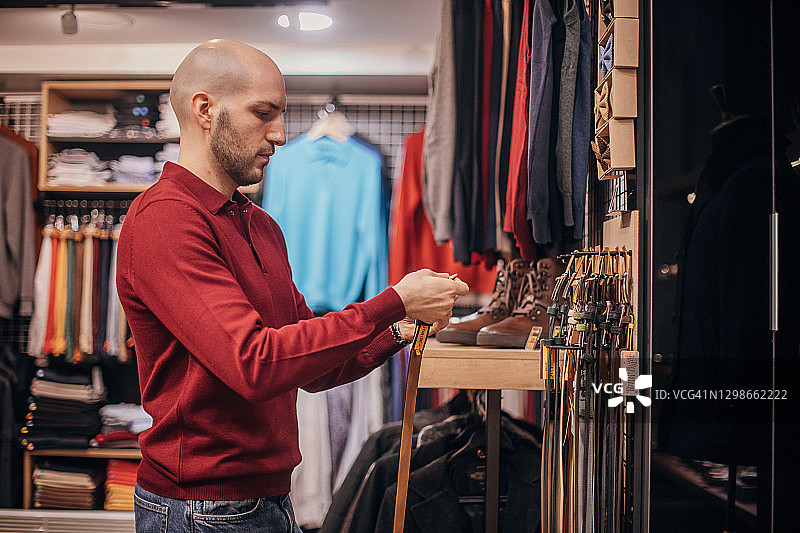 男人在时装店挑选新腰带图片素材