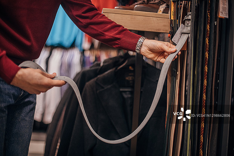 男人在时装店挑选新腰带图片素材